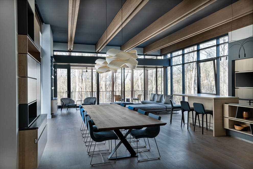 Large industrial open plan dining room in Charlotte with medium hardwood flooring, brown floors and exposed beams.