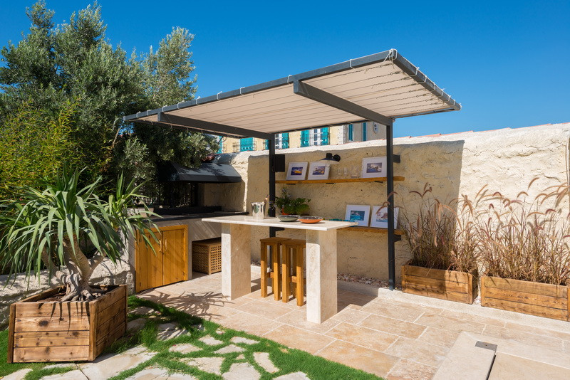 Inspiration for an expansive mediterranean front patio with an outdoor kitchen, natural stone paving and a pergola.