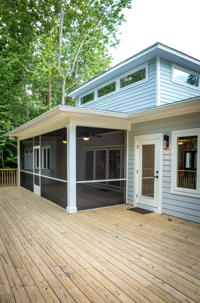 Example of a mid-sized classic backyard ground level wood railing deck design with a roof extension
