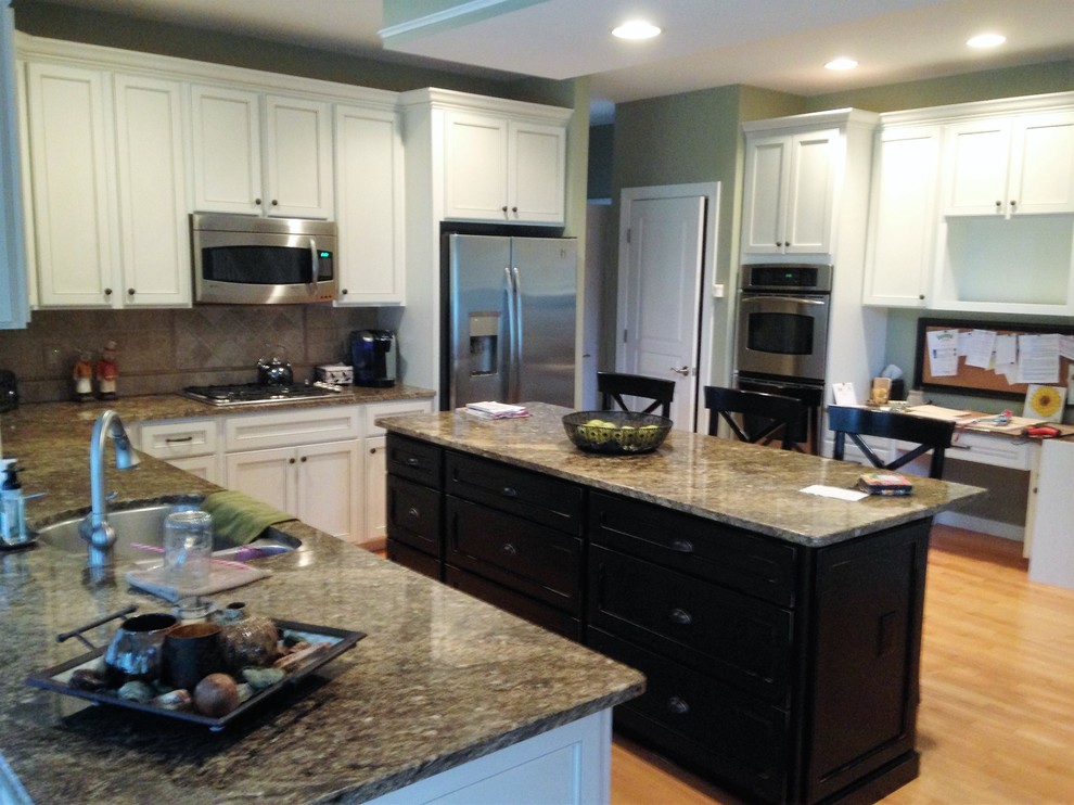 Eat-in kitchen - large u-shaped light wood floor eat-in kitchen idea in Philadelphia with an undermount sink, shaker cabinets, white cabinets, granite countertops, beige backsplash, ceramic backsplash, stainless steel appliances and an island