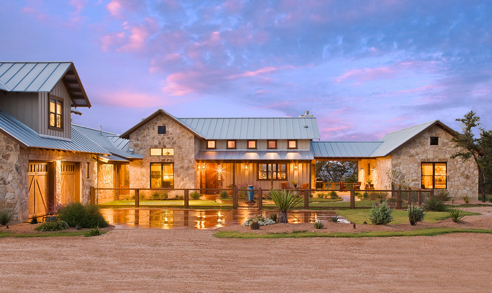 Country exterior in Austin with stone veneer and a metal roof.