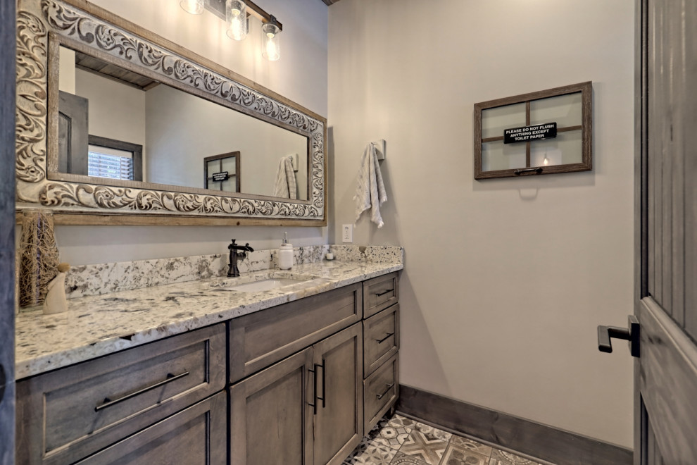 This is an example of a mid-sized arts and crafts bathroom in Atlanta with shaker cabinets, grey cabinets, a two-piece toilet, grey walls, ceramic floors, an undermount sink, granite benchtops, multi-coloured floor, multi-coloured benchtops, an enclosed toilet, a single vanity, a built-in vanity and wood.