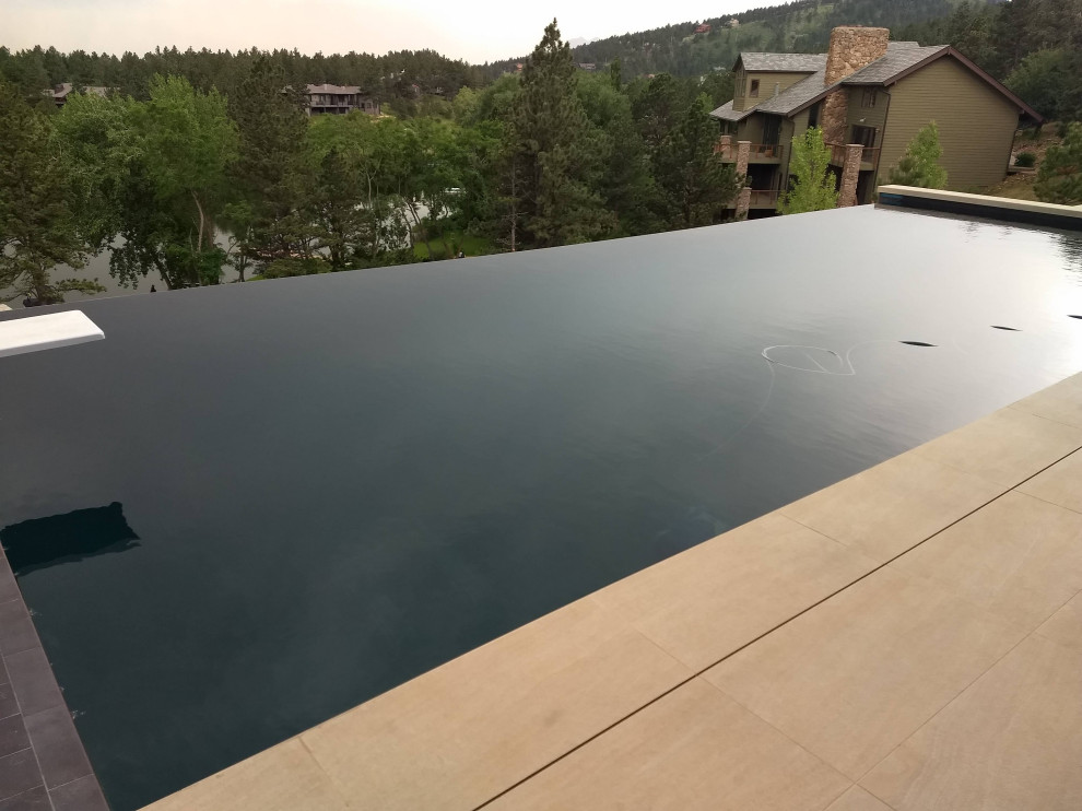 Mid-sized backyard rectangular infinity hot tub photo in Denver