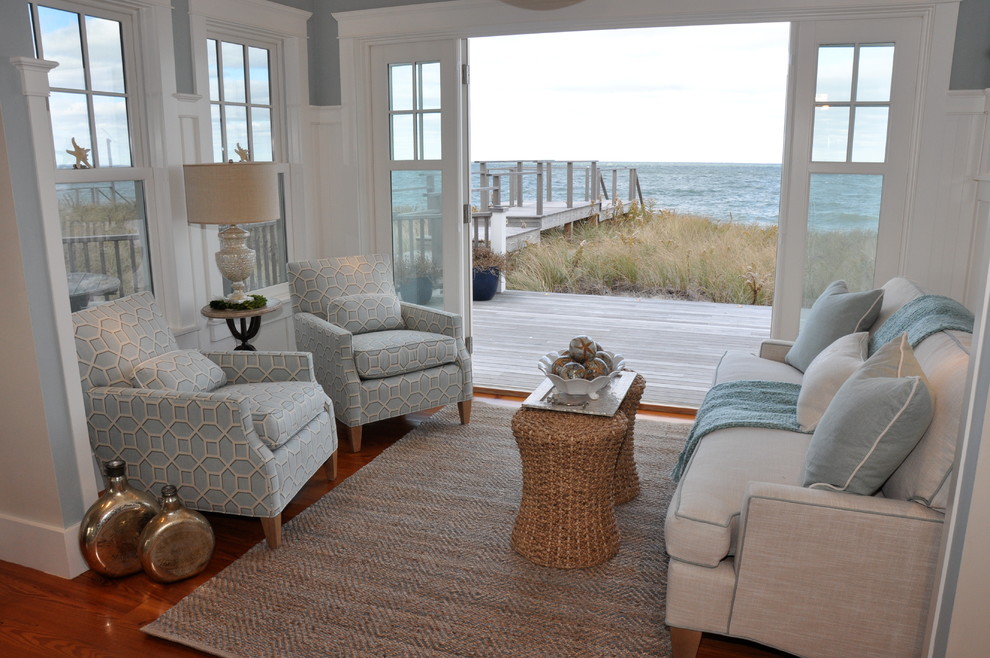 Inspiration for a mid-sized beach style open concept living room in Boston with beige walls, medium hardwood floors, a wood fireplace surround, a wall-mounted tv, a ribbon fireplace and brown floor.