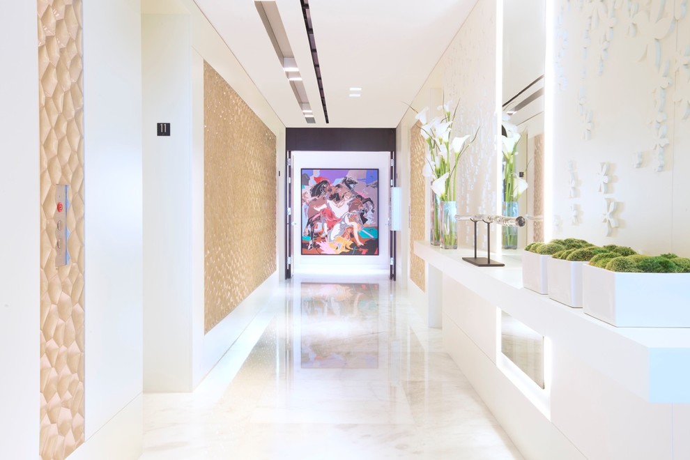 This is an example of an expansive contemporary entry hall in Miami with white walls, marble floors, a double front door and a white front door.
