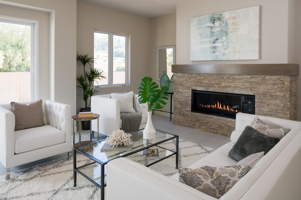 Photo of a large modern formal open concept living room in San Diego with white walls, porcelain floors, a standard fireplace, a stone fireplace surround, a wall-mounted tv and grey floor.
