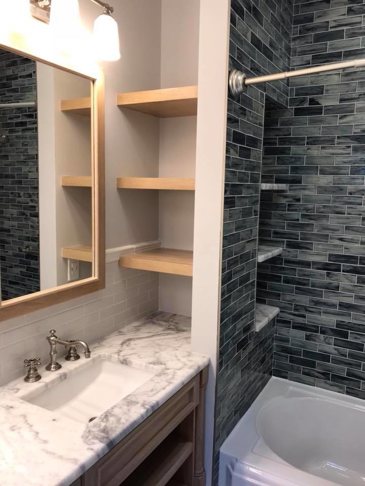 Photo of a mid-sized transitional 3/4 bathroom in New York with beaded inset cabinets, light wood cabinets, an alcove tub, a shower/bathtub combo, gray tile, subway tile, white walls, porcelain floors, an undermount sink, white floor and a shower curtain.