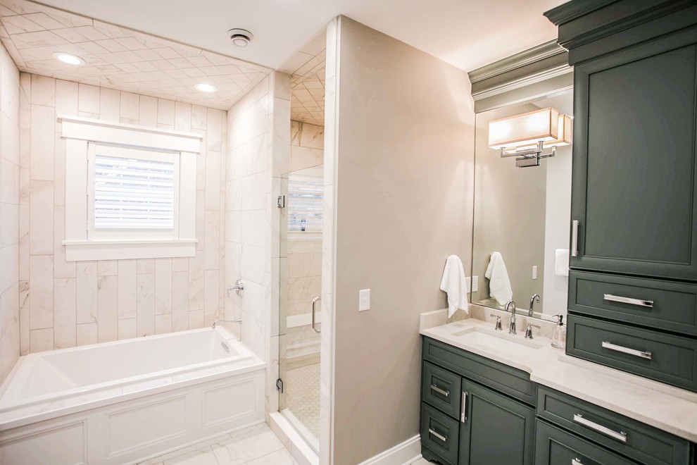 Inspiration for a large transitional master porcelain tile drop-in bathtub remodel with recessed-panel cabinets, gray cabinets, an undermount sink, quartz countertops and a hinged shower door