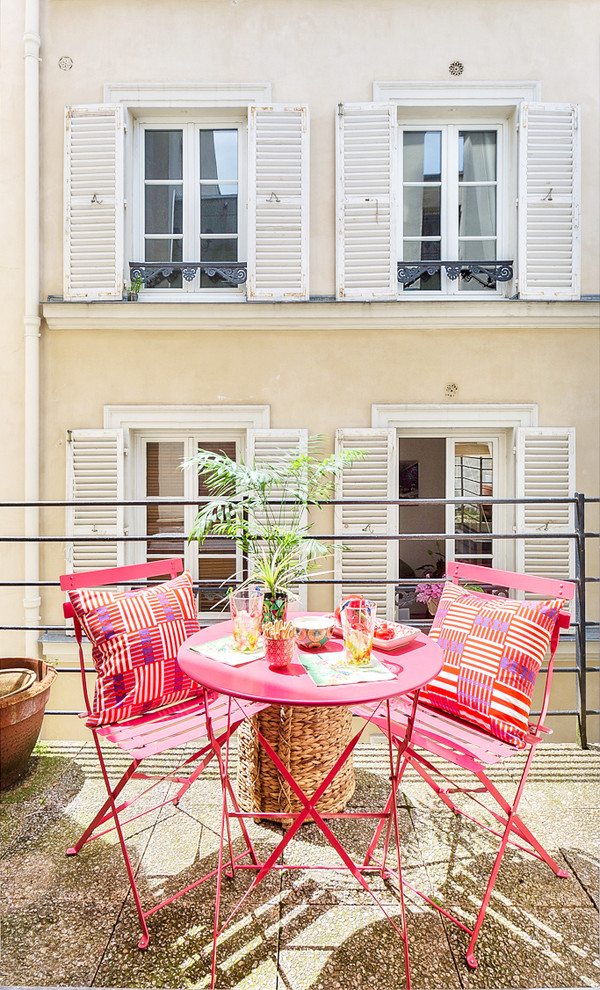 Design ideas for a mid-sized tropical courtyard patio in Paris with concrete pavers and no cover.