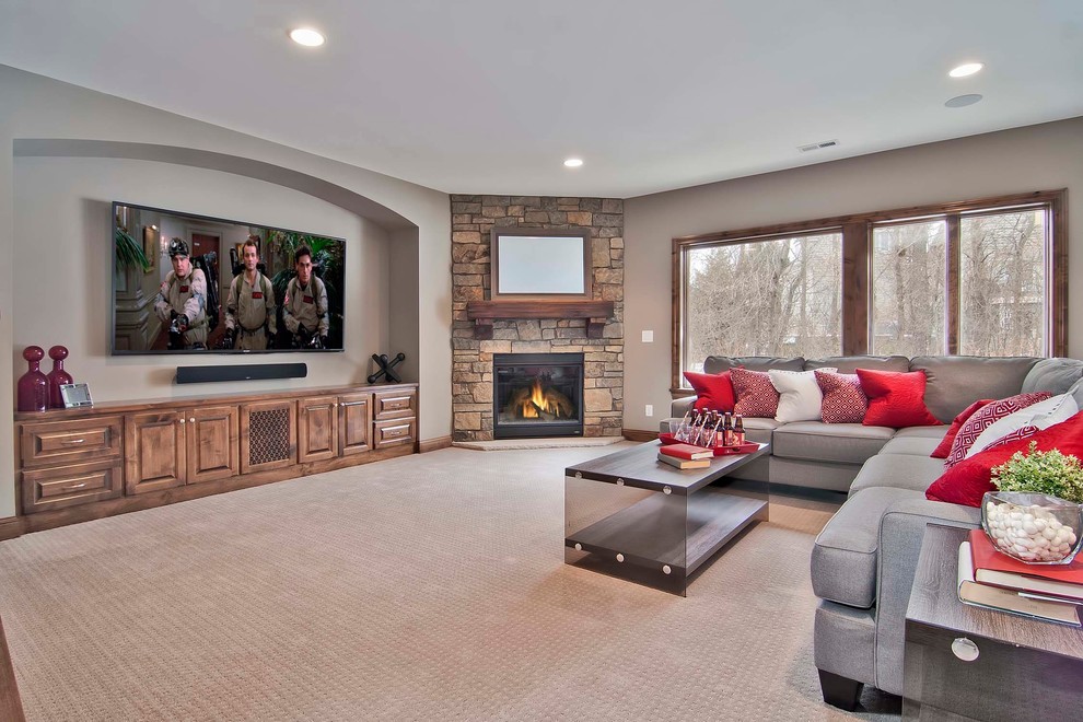 This is an example of an expansive country walk-out basement in Minneapolis with grey walls, carpet, a standard fireplace and a stone fireplace surround.