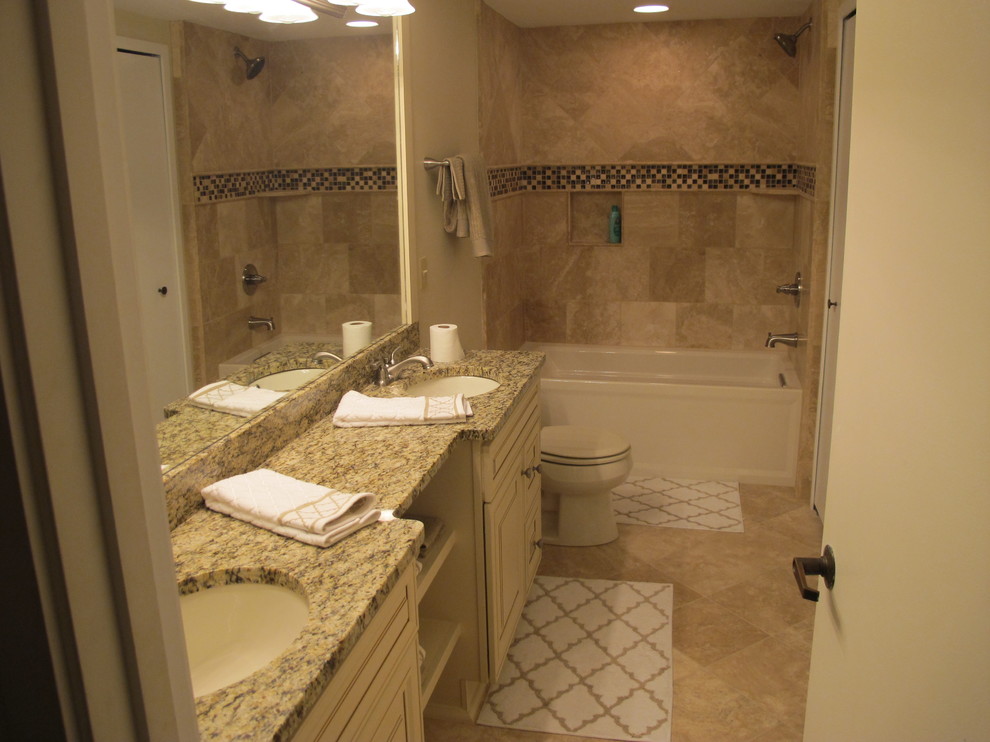 Mid-sized transitional beige tile and stone tile porcelain tile alcove bathtub photo with an undermount sink, raised-panel cabinets, white cabinets, marble countertops and beige walls
