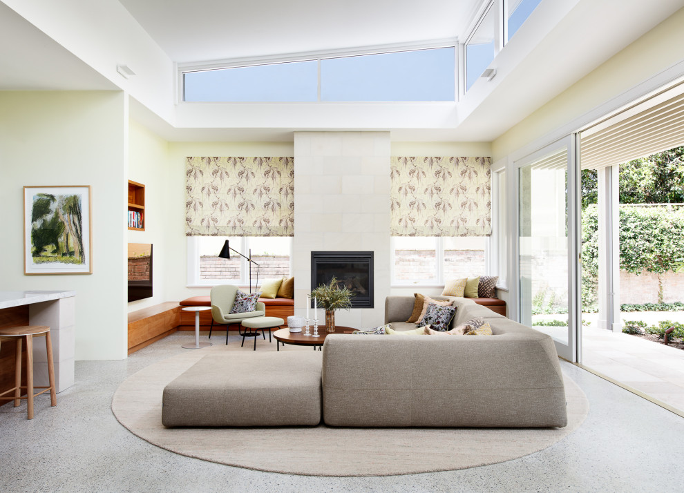 Inspiration for a contemporary family room in Sydney with concrete floors, a standard fireplace, a stone fireplace surround, a wall-mounted tv and grey floor.