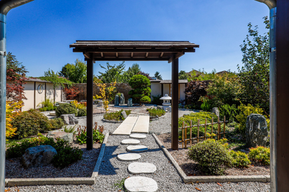 Imagen de acceso privado de estilo de casa de campo de tamaño medio en primavera en patio con fuente y adoquines de piedra natural