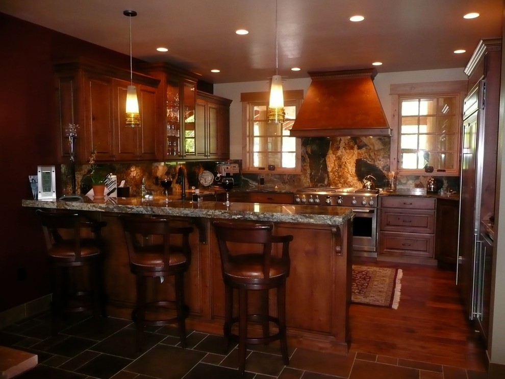 Open concept kitchen - mid-sized rustic u-shaped medium tone wood floor open concept kitchen idea in Seattle with raised-panel cabinets, dark wood cabinets, multicolored backsplash, stone slab backsplash, stainless steel appliances and a peninsula
