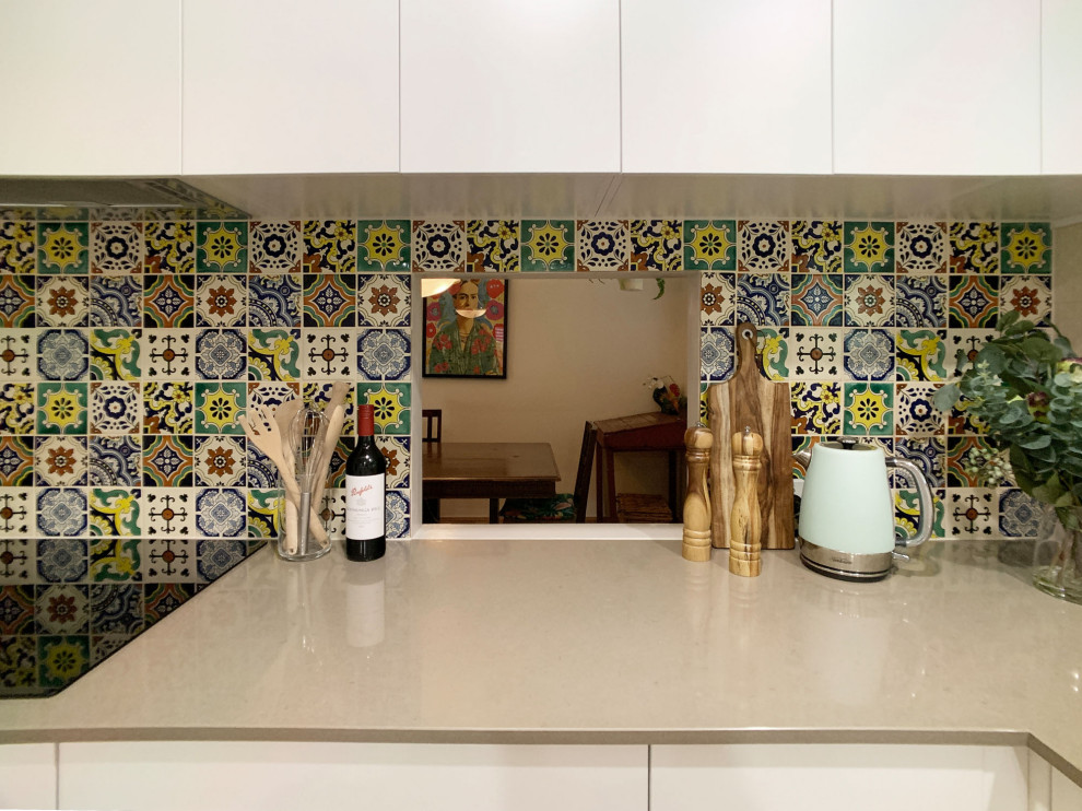 Mid-sized transitional u-shaped separate kitchen in Brisbane with a single-bowl sink, shaker cabinets, white cabinets, quartz benchtops, multi-coloured splashback, mosaic tile splashback, stainless steel appliances, light hardwood floors, a peninsula, brown floor and brown benchtop.