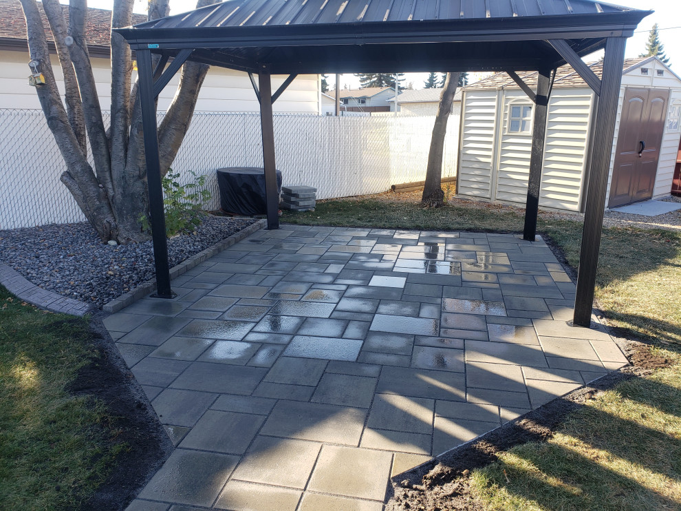 This is an example of a mid-sized rustic partial sun backyard concrete paver landscaping in Edmonton for summer.