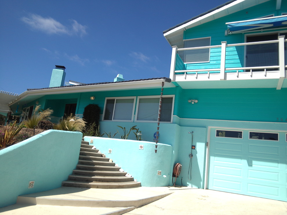 This is an example of a large beach style two-storey blue exterior in San Diego with wood siding.