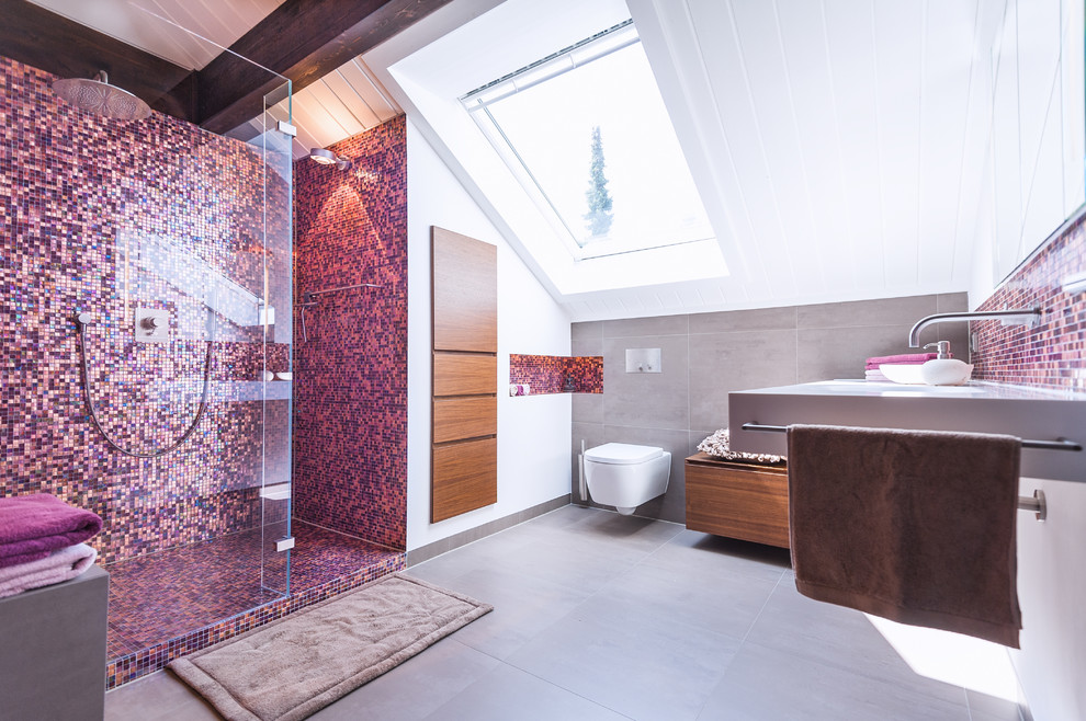Design ideas for a mid-sized contemporary 3/4 bathroom in Frankfurt with a wall-mount sink, an alcove shower, a wall-mount toilet, pink tile, mosaic tile, white walls, medium wood cabinets and ceramic floors.