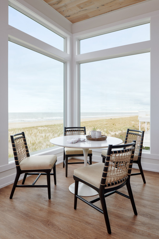 Design ideas for a beach style dining room in New York with medium hardwood floors and brown floor.