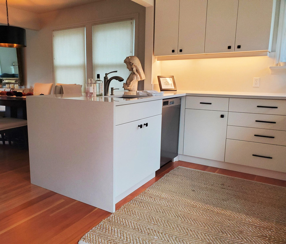 シアトルにあるお手頃価格の中くらいなトランジショナルスタイルのおしゃれなキッチン (フラットパネル扉のキャビネット、白いキャビネット、クオーツストーンカウンター、白いキッチンカウンター) の写真