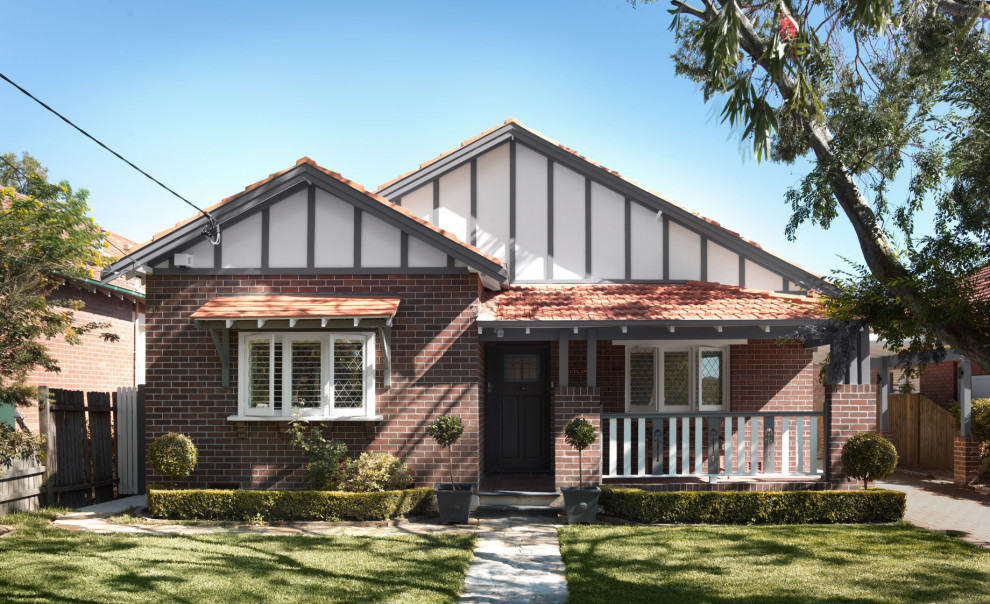 Large transitional one-storey brick brown house exterior in Sydney with a gable roof and a tile roof.