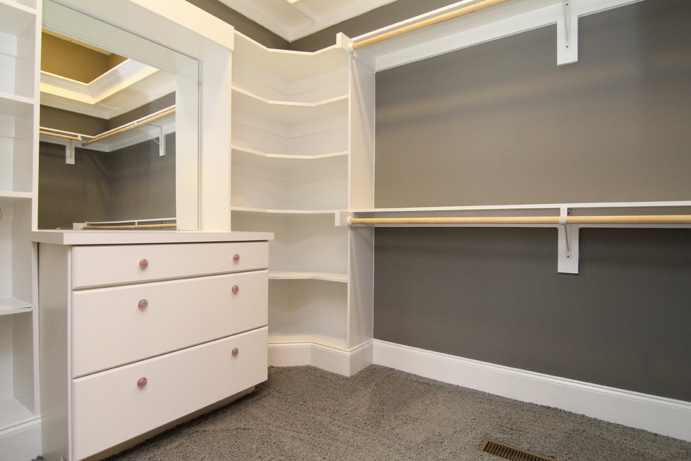 Inspiration for a large transitional gender-neutral dressing room in Raleigh with white cabinets and carpet.