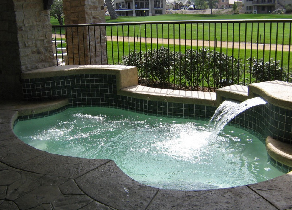 Photo of a small backyard custom-shaped natural pool in Denver with a hot tub and stamped concrete.