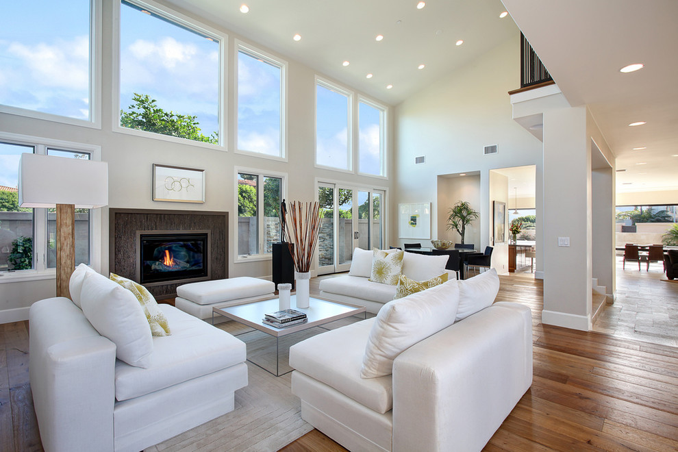 Photo of a transitional living room in Orange County with beige walls, medium hardwood floors and a standard fireplace.