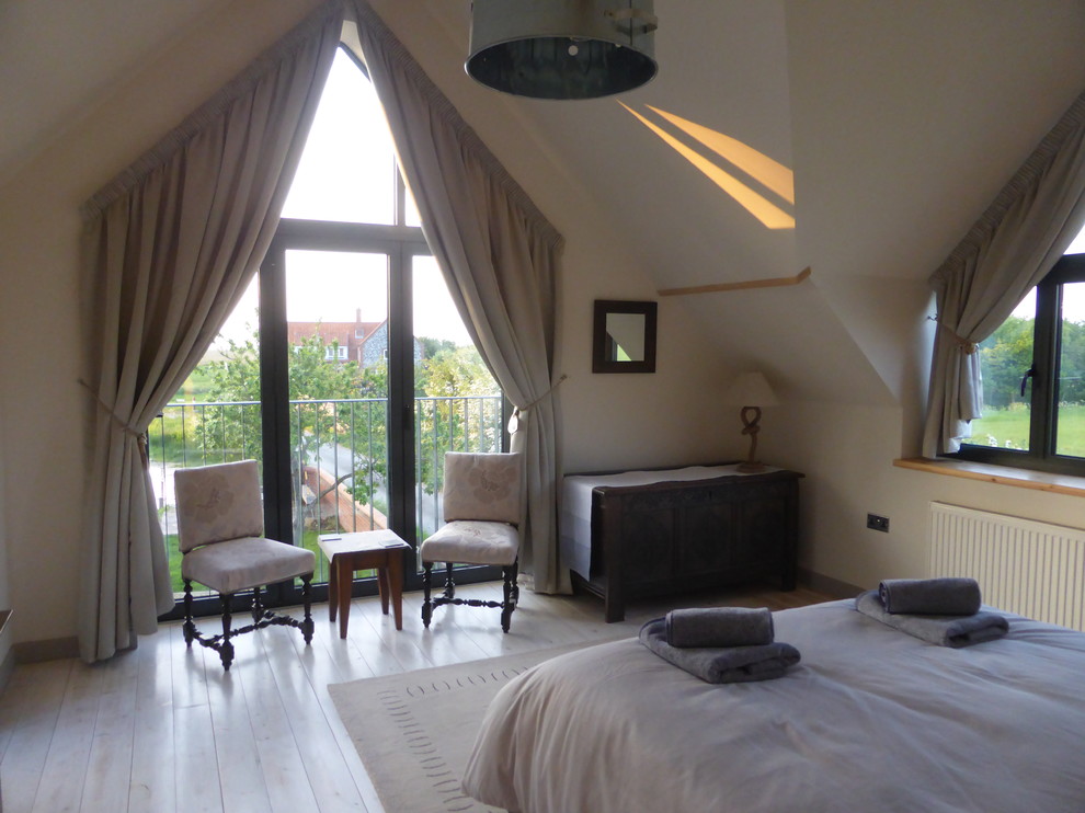 Large coastal master bedroom with painted wood flooring.