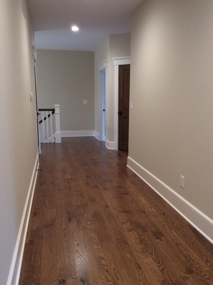 Design ideas for a large country hallway in Columbus with beige walls and dark hardwood floors.