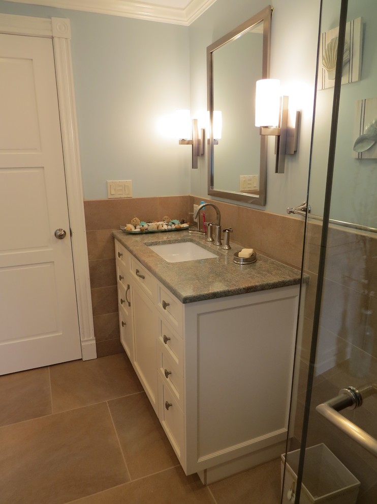 Mid-sized contemporary 3/4 bathroom in Portland Maine with an undermount sink, recessed-panel cabinets, white cabinets, granite benchtops, a two-piece toilet, blue walls, porcelain floors, a curbless shower and porcelain tile.