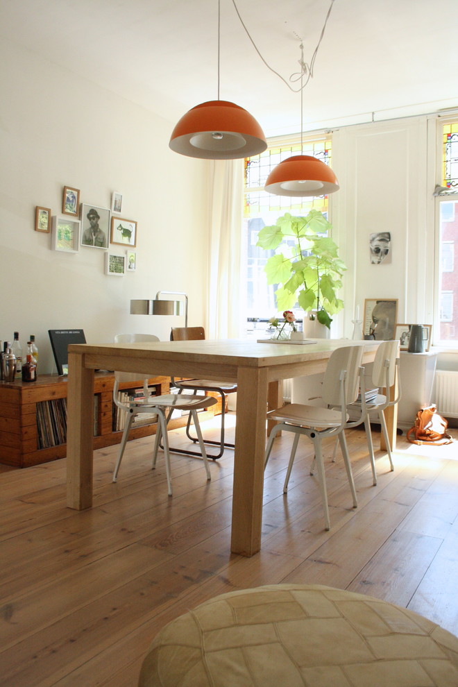 Inspiration for a scandinavian dining room in Amsterdam with white walls and medium hardwood floors.