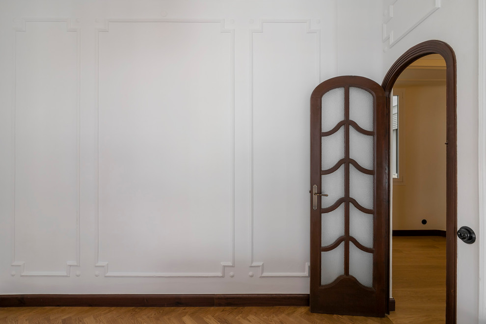 Imagen de dormitorio principal clásico renovado grande con paredes blancas, suelo de madera en tonos medios y suelo marrón