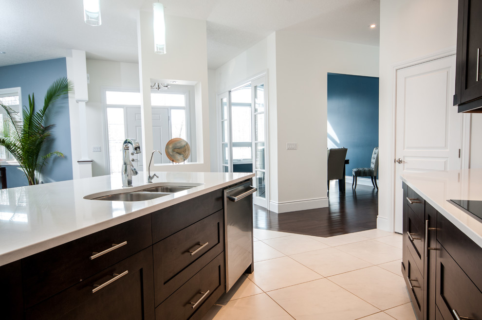 Mid-sized transitional single-wall porcelain tile enclosed kitchen photo in Toronto with an undermount sink, shaker cabinets, dark wood cabinets, white backsplash, subway tile backsplash, stainless steel appliances, an island and solid surface countertops
