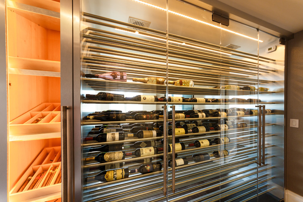 This is an example of a large contemporary wine cellar in New York with display racks.