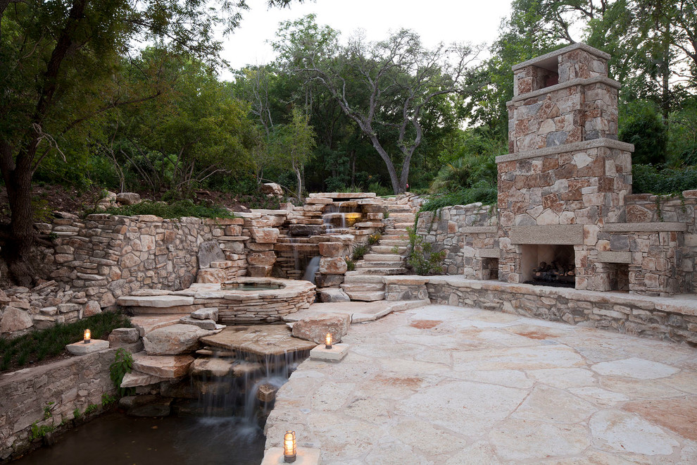 Photo of a mid-sized traditional backyard custom-shaped natural pool in Austin with a hot tub and natural stone pavers.