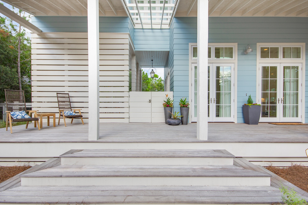 Photo of a beach style verandah in Miami with a container garden, decking and a roof extension.