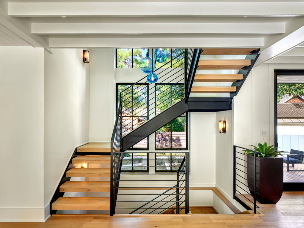 Inspiration for a country wood u-shaped staircase in Other with open risers and cable railing.