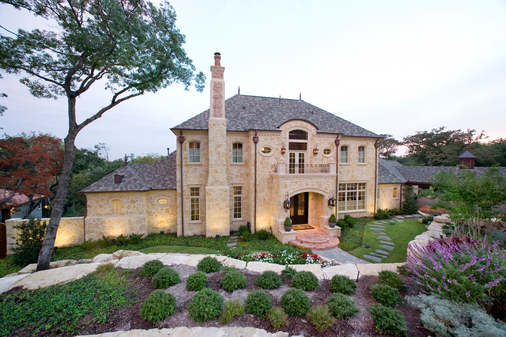 This is an example of a traditional two-storey exterior in Dallas with stone veneer.