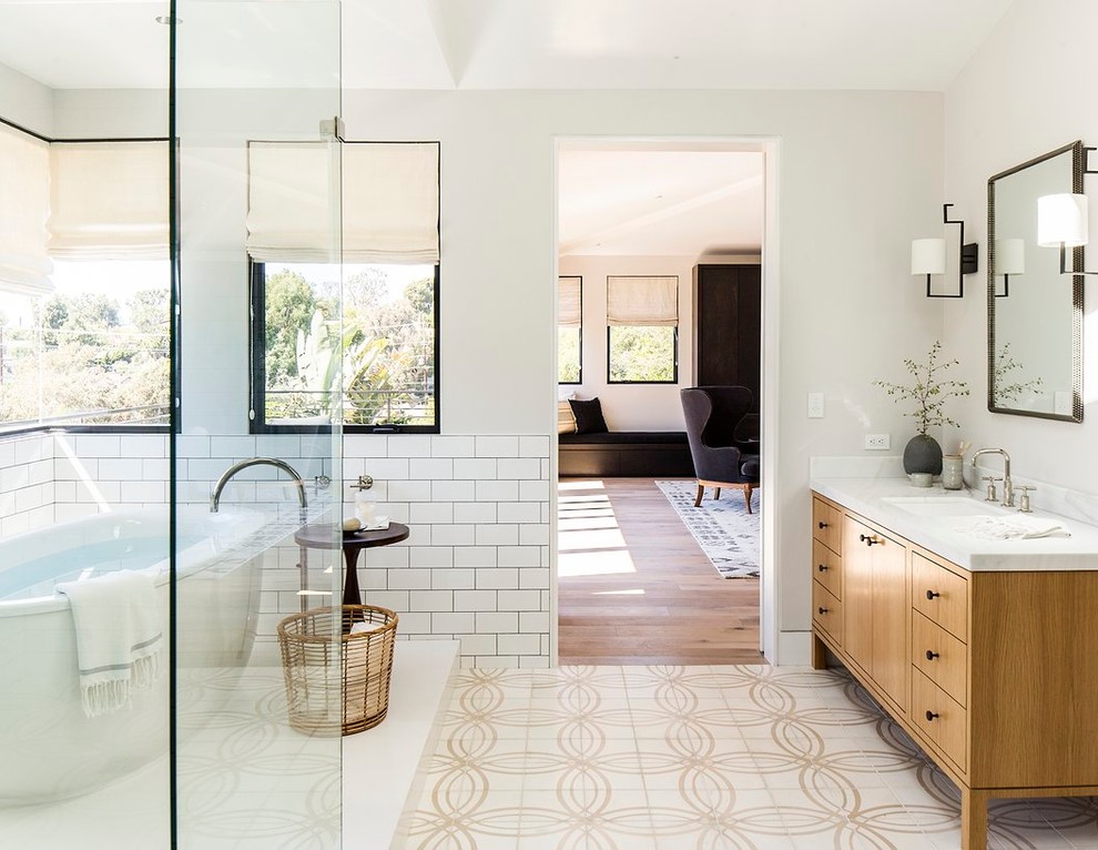 Inspiration for a contemporary bathroom in Los Angeles with an undermount sink, flat-panel cabinets, medium wood cabinets, a freestanding tub, a corner shower, white tile, subway tile and white walls.