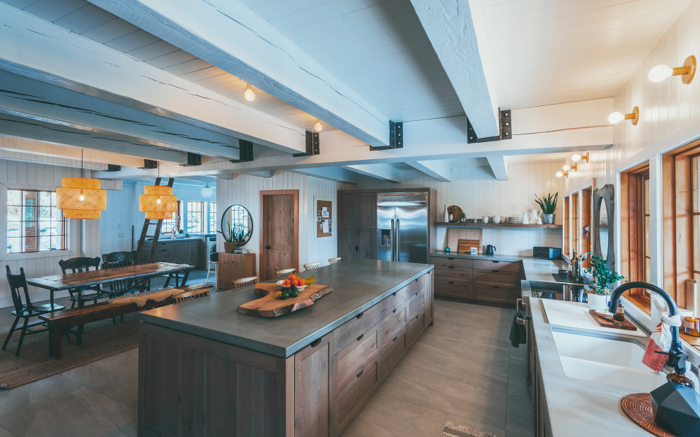 Foto på ett mycket stort lantligt grå kök, med en undermonterad diskho, en köksö, skåp i shakerstil, skåp i mellenmörkt trä, bänkskiva i betong, vitt stänkskydd, rostfria vitvaror, klinkergolv i porslin och beiget golv