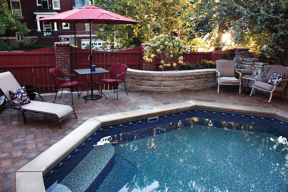 Photo of a small side yard custom-shaped pool in St Louis with brick pavers.