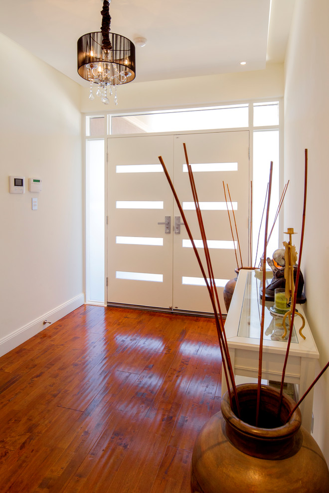 Design ideas for a modern entryway in Adelaide with light hardwood floors, a double front door and a white front door.