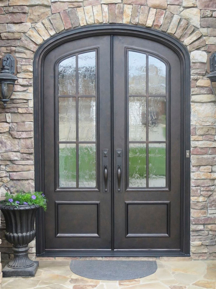 This is an example of a large traditional front door in Charlotte with a double front door, a brown front door and brick walls.
