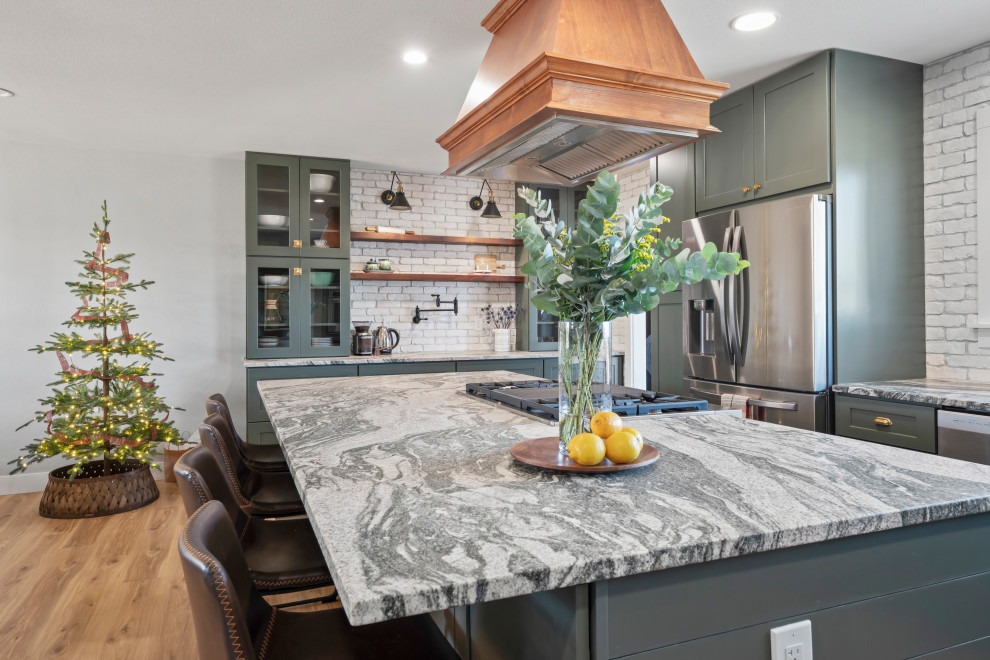 Design ideas for a large country l-shaped eat-in kitchen in Denver with a farmhouse sink, shaker cabinets, green cabinets, granite benchtops, white splashback, brick splashback, stainless steel appliances, vinyl floors, with island, beige floor, grey benchtop and recessed.