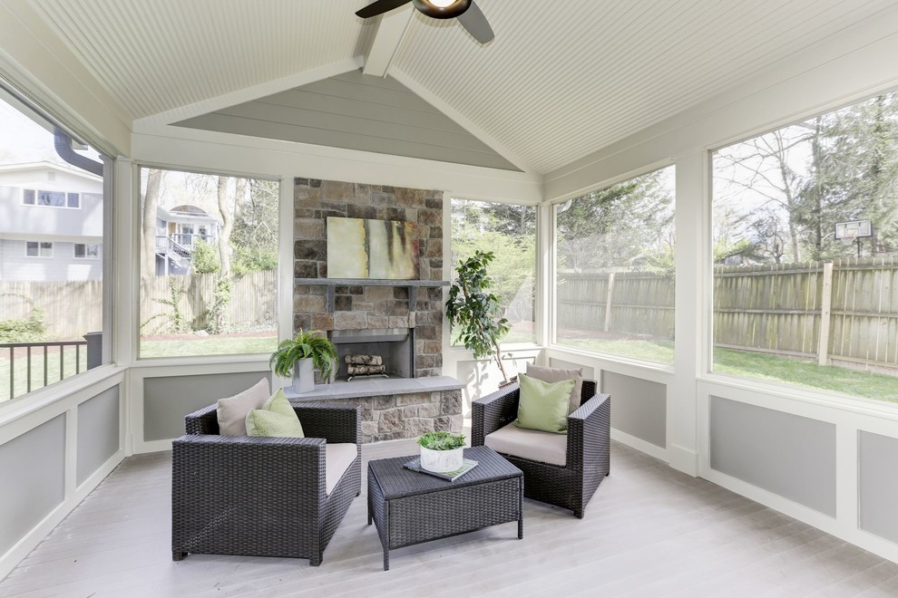 This is an example of a small transitional sunroom in Other with light hardwood floors, a standard fireplace, a stone fireplace surround, a standard ceiling and grey floor.