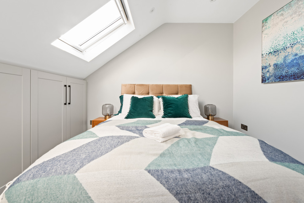 Design ideas for a small contemporary master and grey and teal bedroom in London with white walls, carpet and beige floors.
