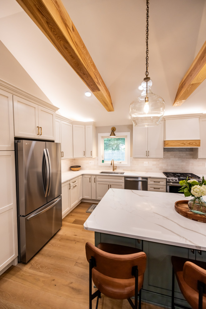 Large transitional l-shaped light wood floor, brown floor and exposed beam eat-in kitchen photo in DC Metro with an undermount sink, shaker cabinets, quartz countertops, white backsplash, porcelain backsplash, stainless steel appliances, an island and white countertops