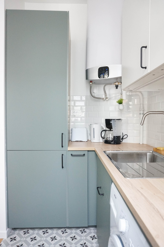 Photo of a small contemporary l-shaped open plan kitchen in Paris with flat-panel cabinets, green cabinets, wood benchtops, white splashback, subway tile splashback, cement tiles, no island and grey floor.