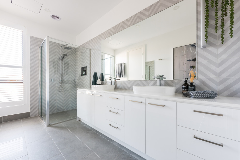 Design ideas for a mid-sized contemporary master bathroom in Melbourne with flat-panel cabinets, white cabinets, a corner shower, a two-piece toilet, gray tile, ceramic tile, white walls, porcelain floors, a vessel sink, engineered quartz benchtops, grey floor, a hinged shower door and white benchtops.